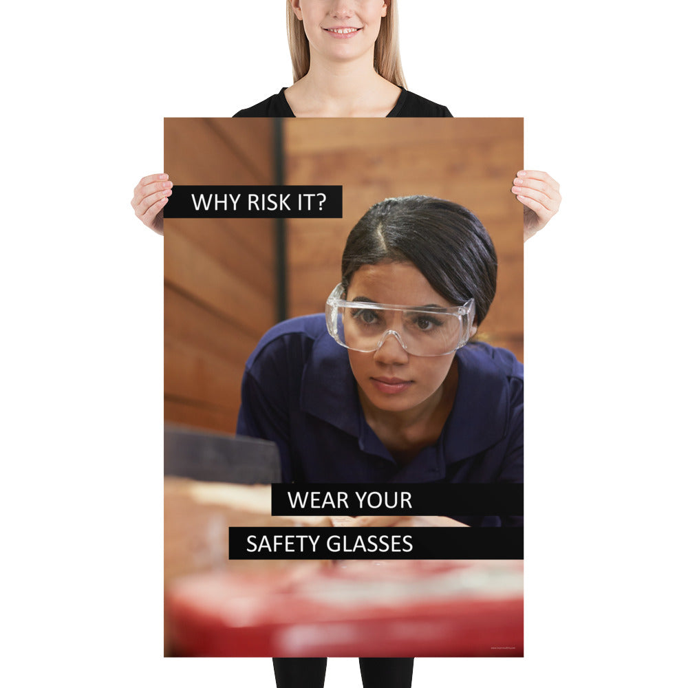 A safety poster showing a woman using a table saw to cut wood wearing safety glasses with the slogan "Why Risk It? Wear Your Safety Glasses."