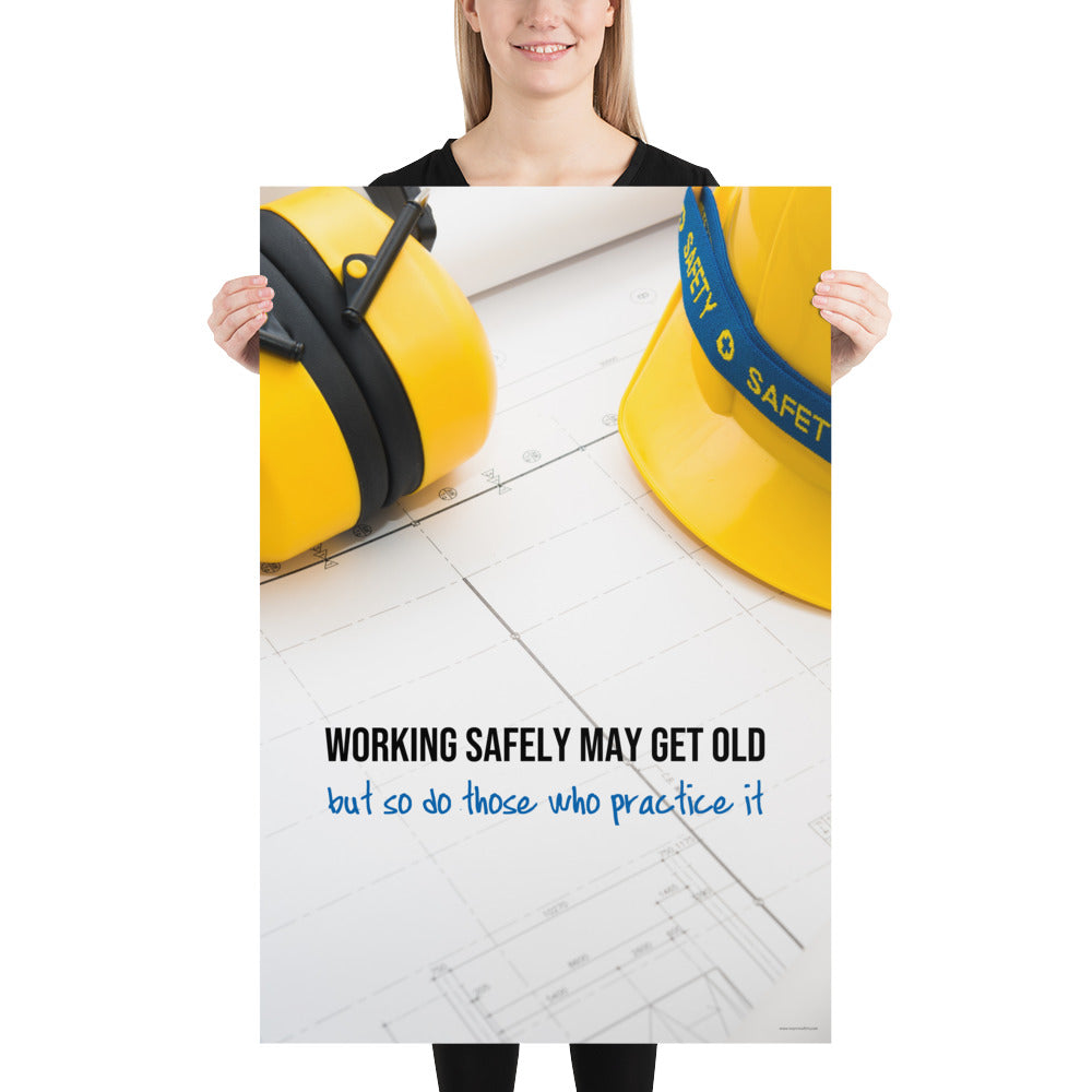 A construction safety poster showing yellow ear muffs and a hard hat resting on blueprints with the slogan "Working safely may get old, but so do those who practice it."