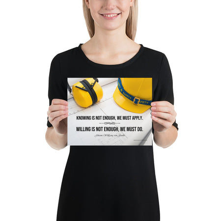A safety poster showing a yellow hard hat and yellow ear muffs on blueprints with a safety quote by Johann Wolfgang von Goethe that says "Knowing is not enough, we must apply. Willing is not enough, we must do."