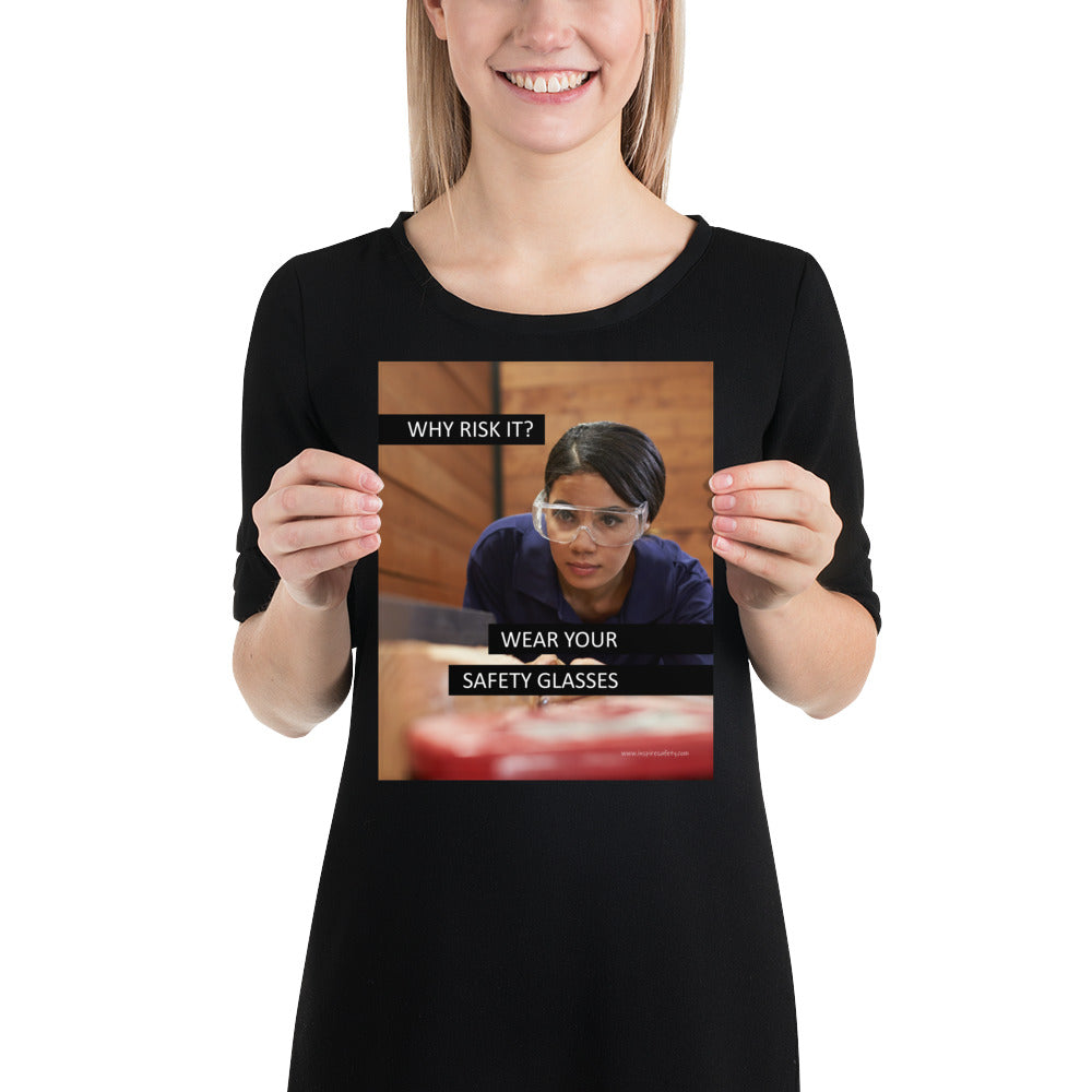 A safety poster showing a woman using a table saw to cut wood wearing safety glasses with the slogan "Why Risk It? Wear Your Safety Glasses."