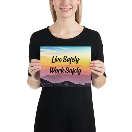 A safety poster showing a mountain range with a beautiful gradient in the sky of blue, yellow, and pink with the safety slogan "Live Safely Work Safely."
