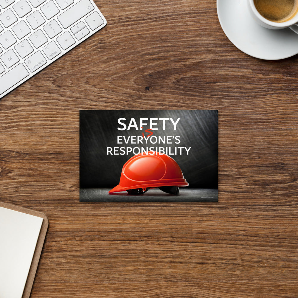 A safety mini print showing a red hard hat in front of a grey, industrial-looking background with the slogan safety is everyone's responsibility.