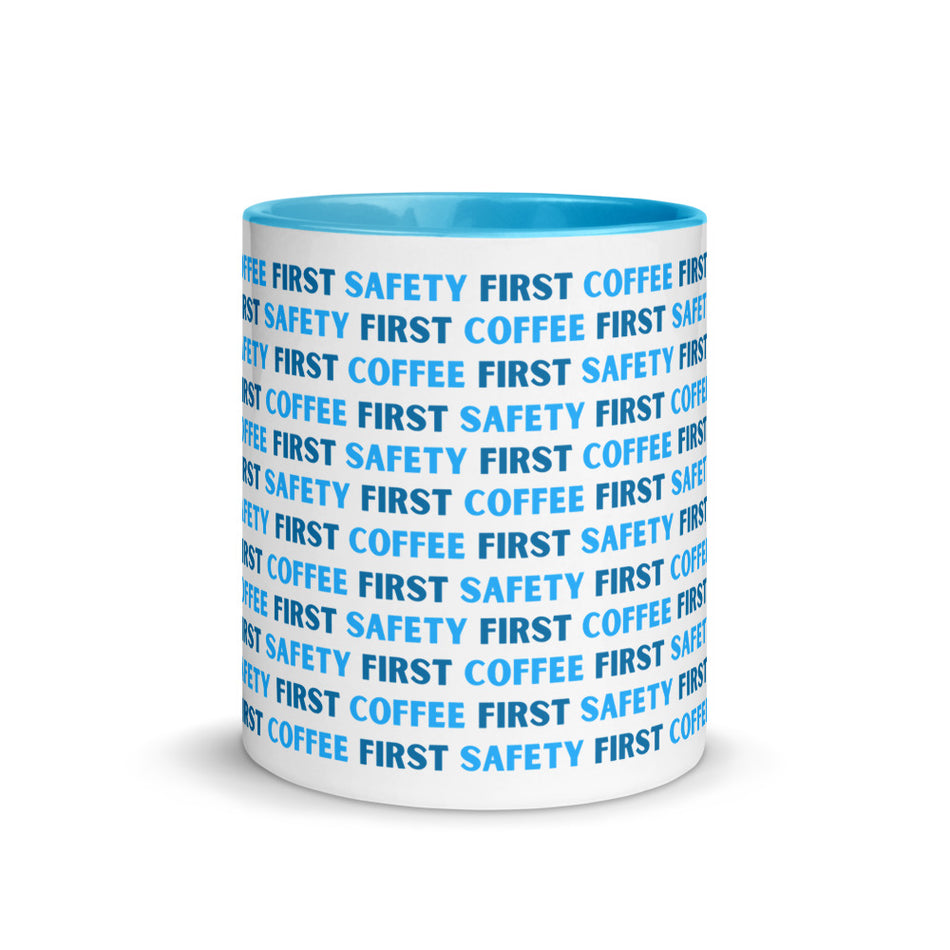 White ceramic mug with blue repeating text that says "Safety First, Coffee First" with a blue rim, inside, and handle.
