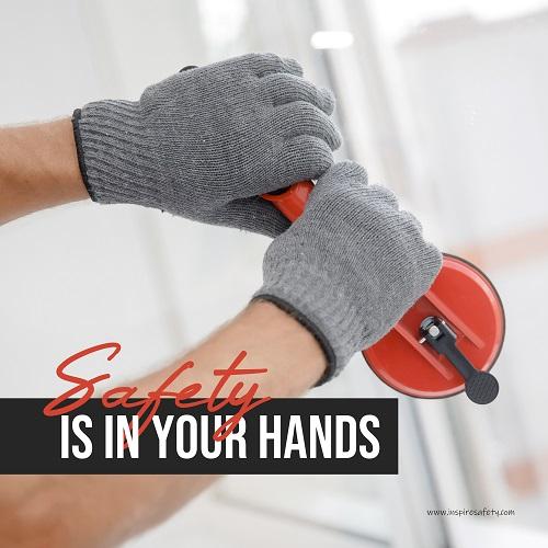 A workplace safety poster showing a close-up of a worker's hands wearing gloves while installing windows with the slogan safety is in your hands.