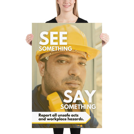 A workplace safety poster showing a solemn man's face wearing a hard hat with the words "See Something, Say Something" with a small banner at the bottom that says "Report all unsafe acts and workplace hazards."