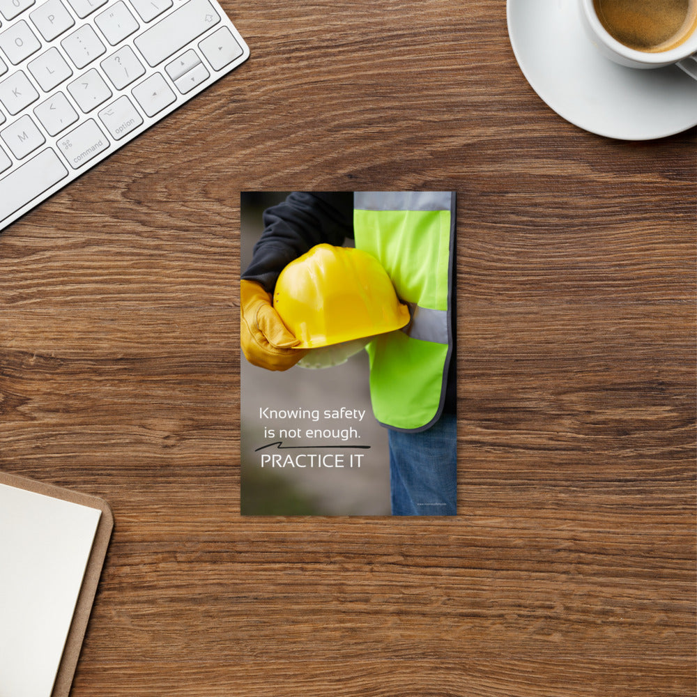 A safety print showing a construction worker in a reflective vest and gloves holding a hard hat with the slogan "Knowing safety is not enough. Practice it."