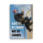 A fully harnessed man wearing a hard hat scaling the side of a building with a bright blue sky and clouds in the background with the text safety by choice, not by chance in bold text to his left.