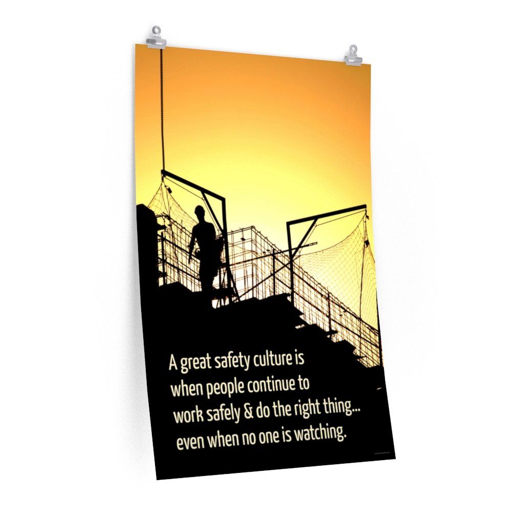 A construction safety poster showing the silhouette of a construction worker working on a building with a bright yellow sunset in the background and a safety slogan in the bottom left corner.