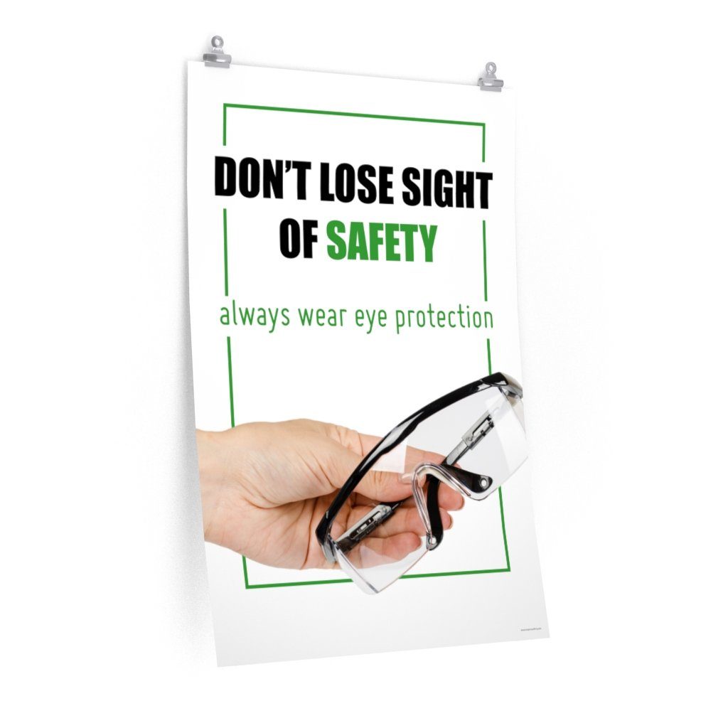 An eye safety slogan showing a close up of a hand presenting out safety glasses with a safety slogan in blue text above.