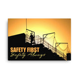 A workplace safety poster showing a construction site and construction workers being silhouetted by a bright and beautiful sunset of different shades of orange with the slogan safety first, safety always.