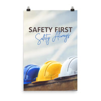 A workplace safety poster showing a white, a yellow, and a blue hardhat sitting on a wall with the slogan safety first, safety always.