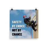 A fully harnessed man wearing a hard hat scaling the side of a building with a bright blue sky and clouds in the background with the text safety by choice, not by chance in bold text to his left.