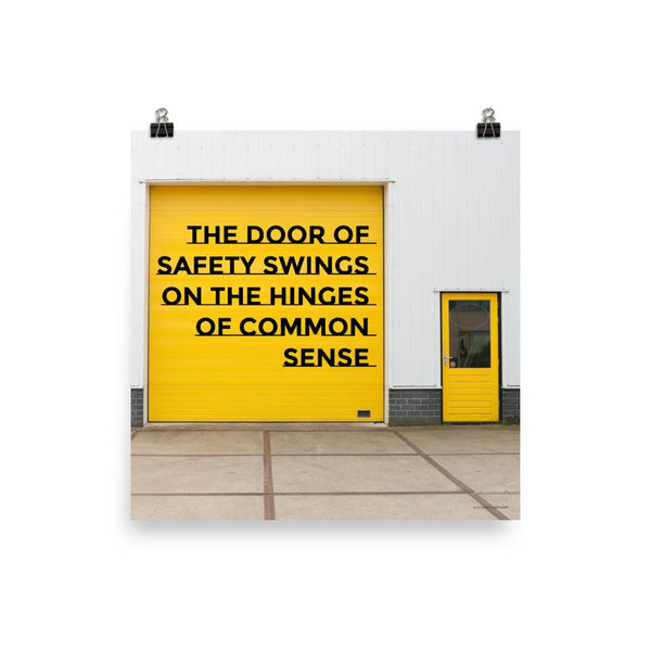 Workplace safety poster depicting a bright yellow garage door to a warehouse with a bold safety slogan on it with a smaller yellow door to the right.