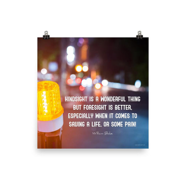A workplace safety poster depicting a bright orange construction traffic light in the foreground of a blurry nighttime cityscape with a safety quote by William Blake.