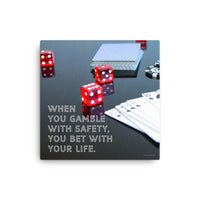 A workplace safety poster of a glossy black table with red dice, playing cards, and poker chips strewn everywhere with a safety slogan in the bottom left corner.