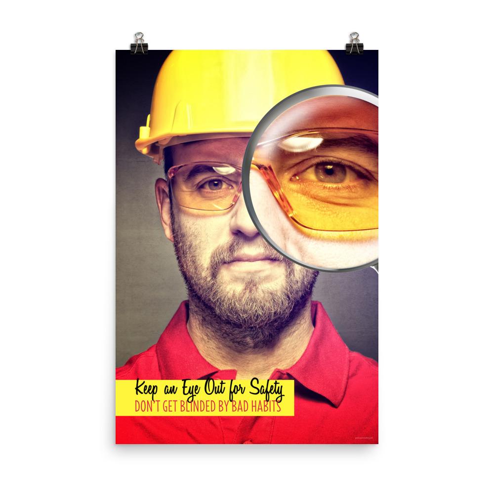 A workplace safety poster showing a portrait of a man wearing a hardhat and safety glasses with a magnifying glass magnifying one eye with the slogan, keep an eye out for safety, don't get blinded by bad habits.