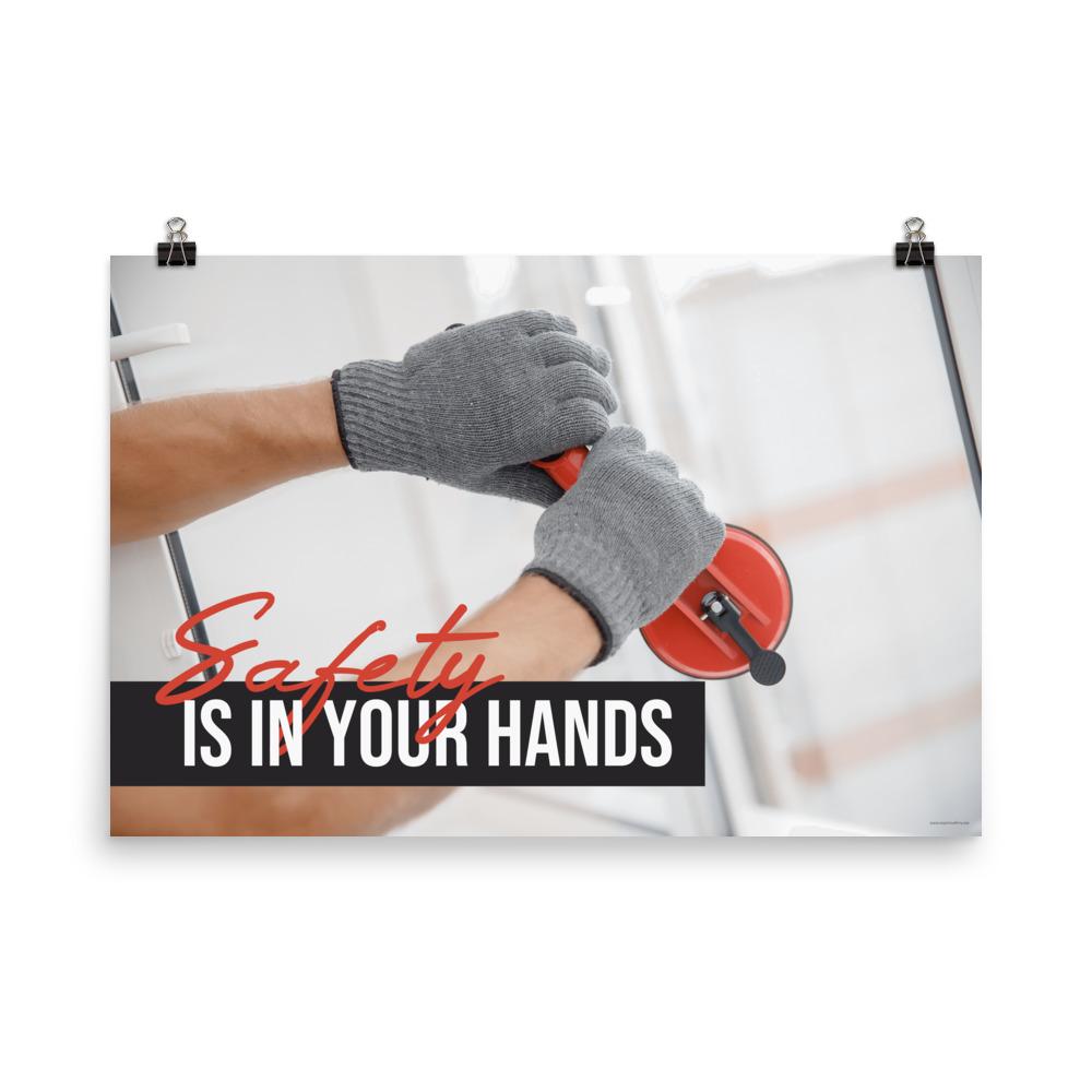 A workplace safety poster showing a close-up of a worker's hands wearing gloves while installing windows with the slogan safety is in your hands.