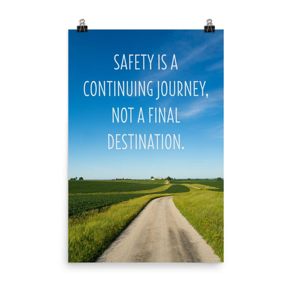 A workplace safety poster depicting a beautiful sunny day with a bright blue sky and a lush green field being cut down the middle by a dirt road leading off into the countryside with the text safety is a continuing journey, not a final destination.