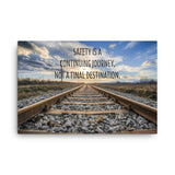 A workplace safety poster depicting old railroad tracks leading into a cloudy horizon with the text safety is a continuing journey, not a final destination.