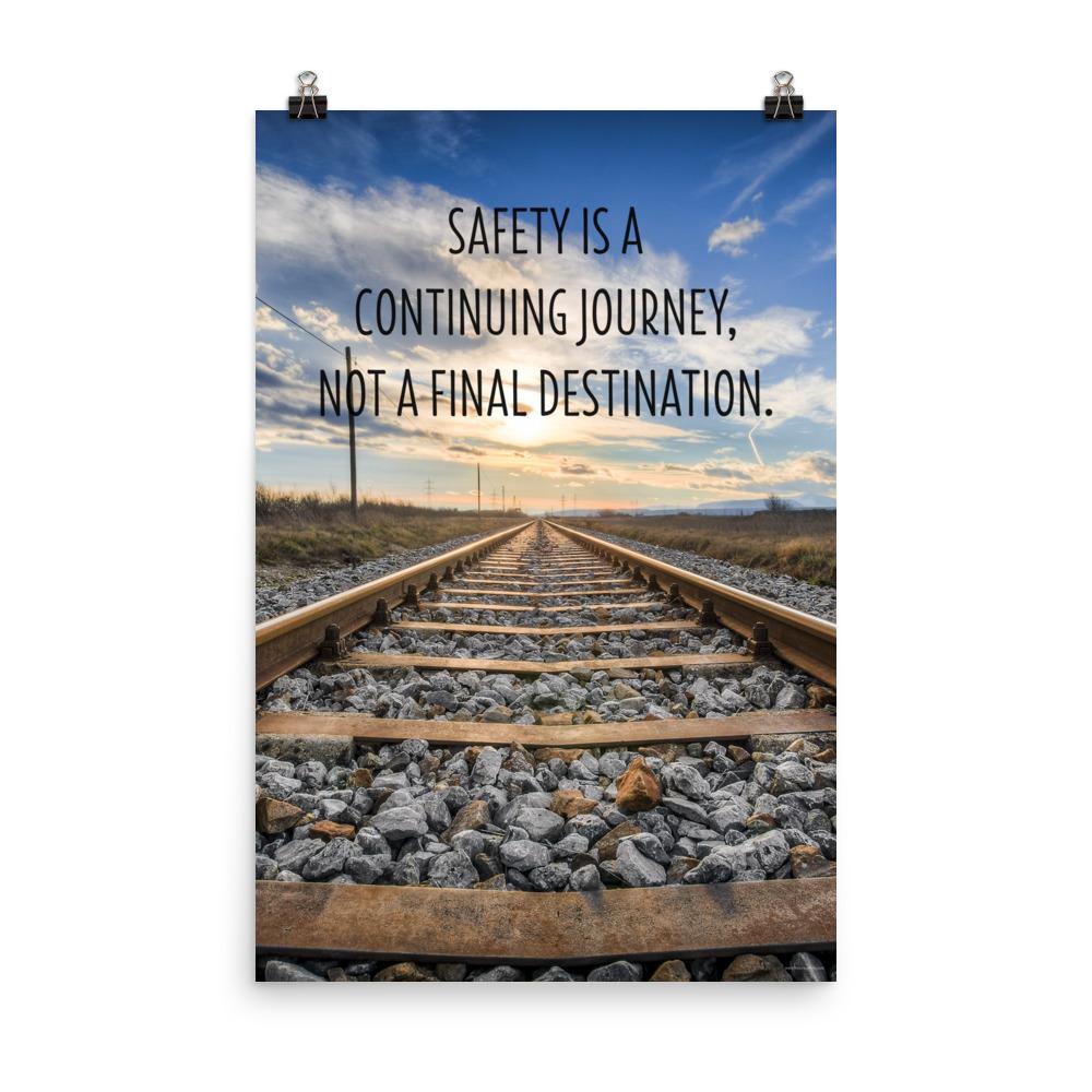 A workplace safety poster depicting old railroad tracks leading into a cloudy horizon with the text safety is a continuing journey, not a final destination.