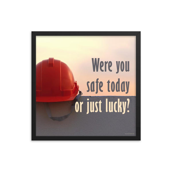 A workplace safety poster showing a red hard hat sitting on a grey wall with a dreamy sunset background and the slogan were you safe today, or just lucky?