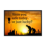 A workplace safety poster showing workers on a construction site being silhouetted in black with a sunset of orange hues in the background with the slogan were you safe today, or just lucky?