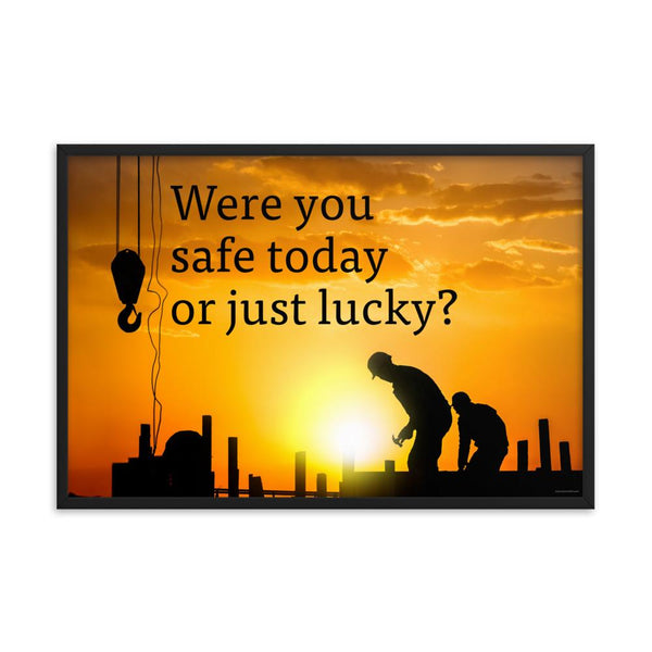 A workplace safety poster showing workers on a construction site being silhouetted in black with a sunset of orange hues in the background with the slogan were you safe today, or just lucky?