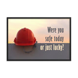 A workplace safety poster showing a red hard hat sitting on a grey wall with a dreamy sunset background and the slogan were you safe today, or just lucky?