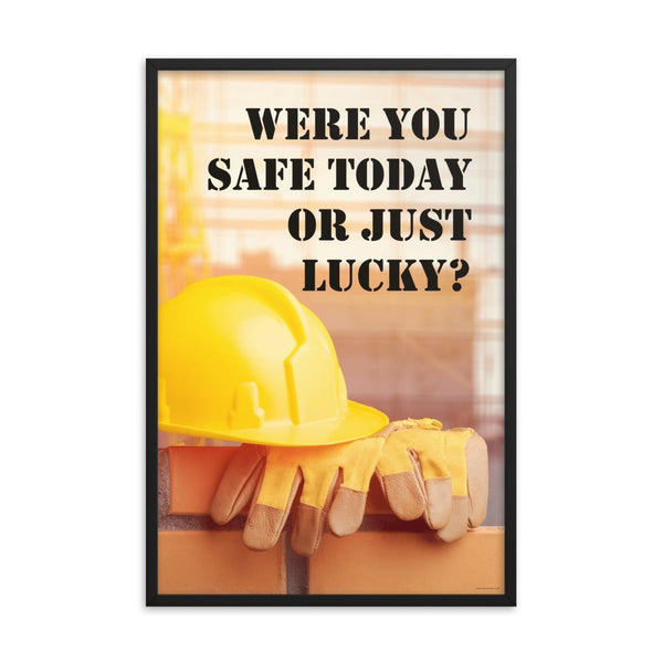A workplace safety poster showing a yellow hard hat and some gloves sitting on a brick wall on a construction site with the slogan were you safe today, or just lucky written in black stencil font.