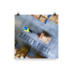 A safety poster showing a bird's-eye view of a worker in a warehouse pulling boxes on a pallet jack with the slogan safety first in bold letters.