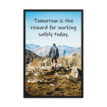 A workplace safety poster showing a man standing on a peak of a mountain with a bright blue sky and mountains behind him with the slogan tomorrow is the reward for working safely today.