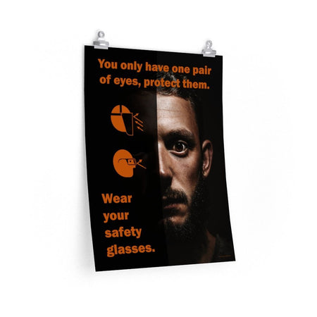 An eye safety poster of a close up of a mans face with his eyes wide open with text and PPE infographics covering his left eye.