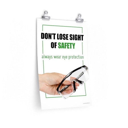 An eye safety slogan showing a close up of a hand presenting out safety glasses with a safety slogan in blue text above.
