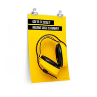 A hearing protection safety poster depicting bright yellow ear muffs on a bright yellow background in the bottom right corner with a bold safety slogan in the upper left corner.