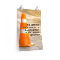 A workplace safety poster showing an orange safety cone with the slogan the near miss reported today is the accident that doesn't happen tomorrow.