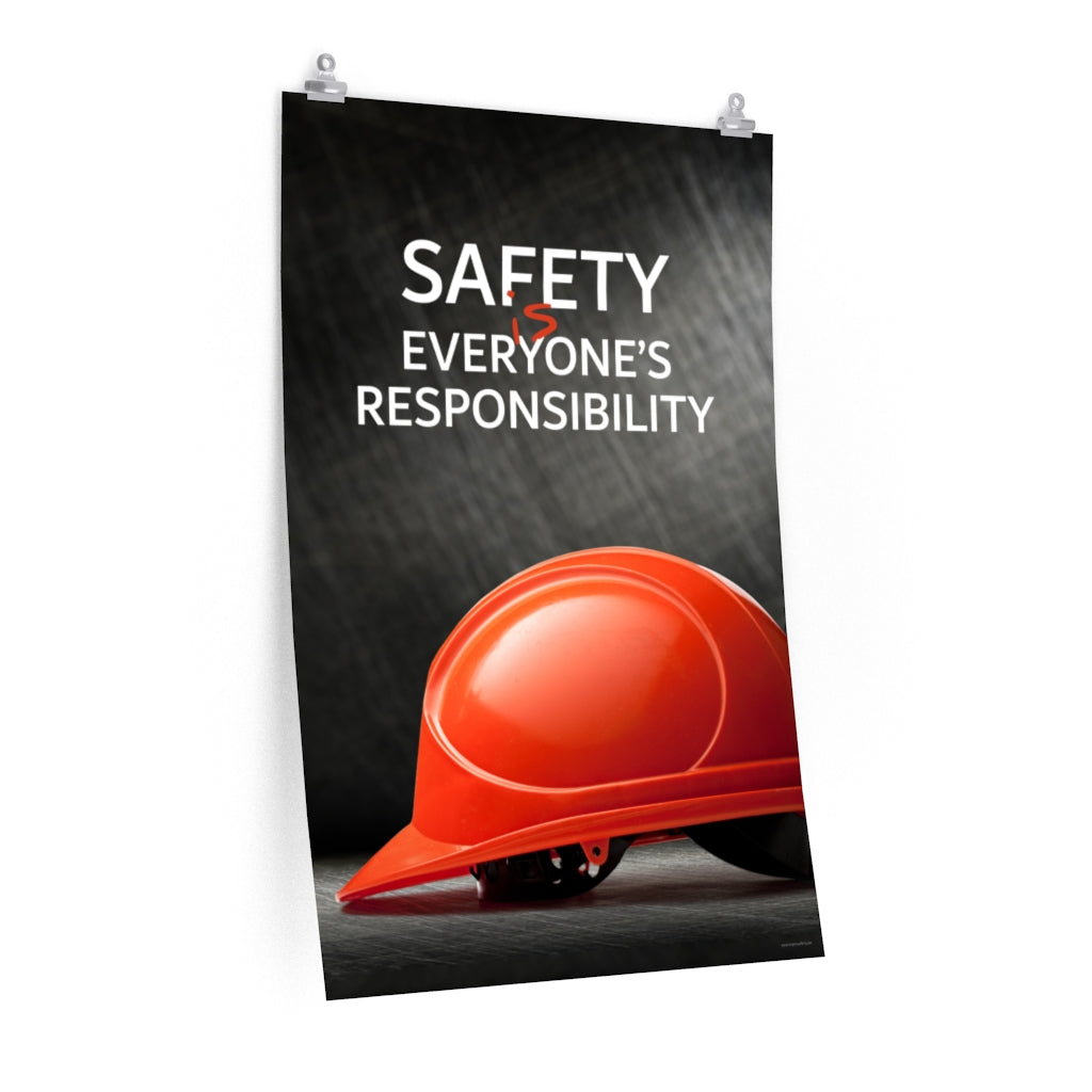 A workplace safety poster showing a red hard hat in front of a grey, industrial-looking background with the slogan safety is everyone's responsibility.