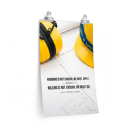 A safety poster showing a yellow hard hat and yellow ear muffs on blueprints with a safety quote by Johann Wolfgang von Goethe that says "Knowing is not enough, we must apply. Willing is not enough, we must do."