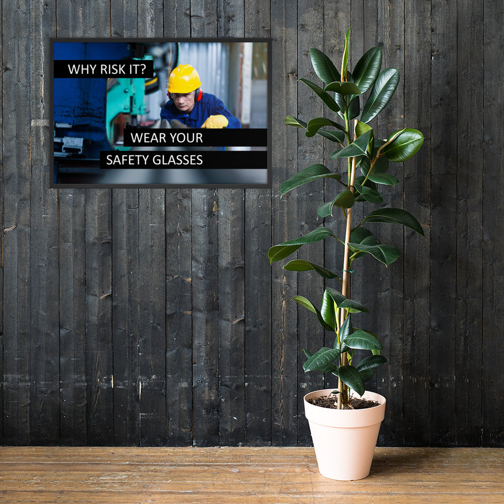 A safety poster showing a worker in a hard hat, ear muffs, safety glasses, and gloves with the slogan "Why Risk It? Wear Your Safety Glasses."