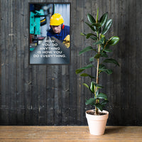 A safety poster showing a man in a yellow hard hat, red earmuffs and safety glasses, working in a factory with the slogan "HOw you do anything is how you do everything" below him.