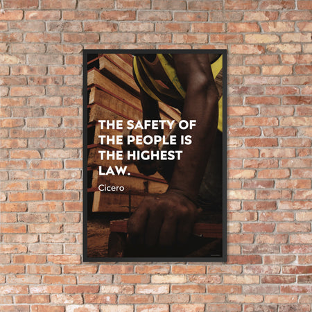 A safety poster of a construction worker in a hi-visibility vest hammering a nail into wood with a safety quote by Cicero that says "The safety of the people is the highest law."