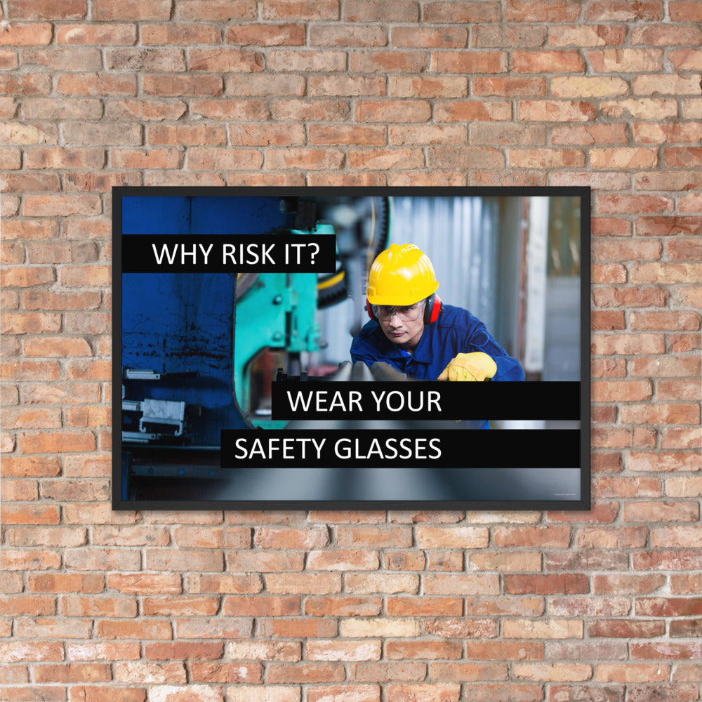 A safety poster showing a worker in a hard hat, ear muffs, safety glasses, and gloves with the slogan "Why Risk It? Wear Your Safety Glasses."