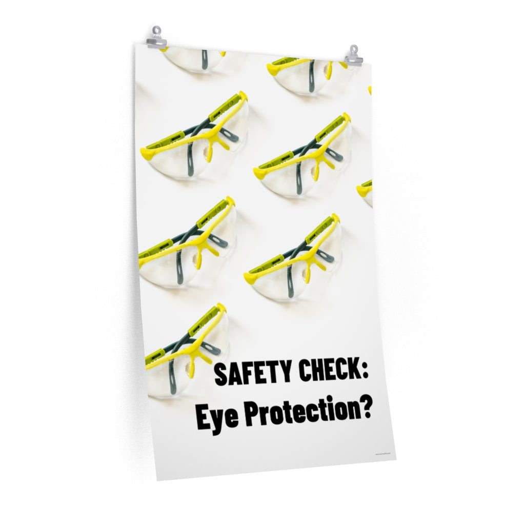 An eye safety poster depicting many clear safety glasses with yellow trim neatly lined up in rows and rows with a safety slogan in the foreground.