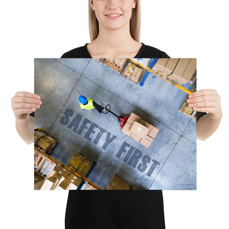 A safety poster showing a bird's-eye view of a worker in a warehouse pulling boxes on a pallet jack with the slogan safety first in bold letters.