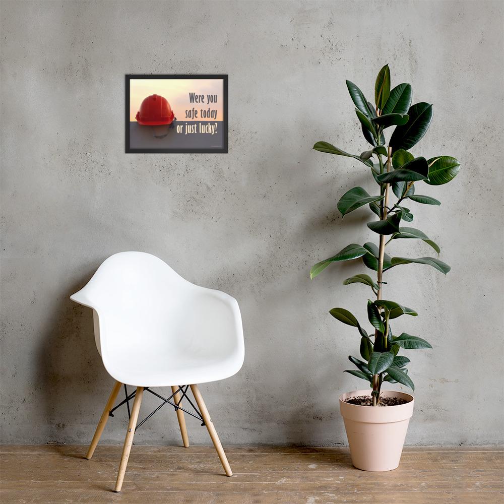 A workplace safety poster showing a red hard hat sitting on a grey wall with a dreamy sunset background and the slogan were you safe today, or just lucky?