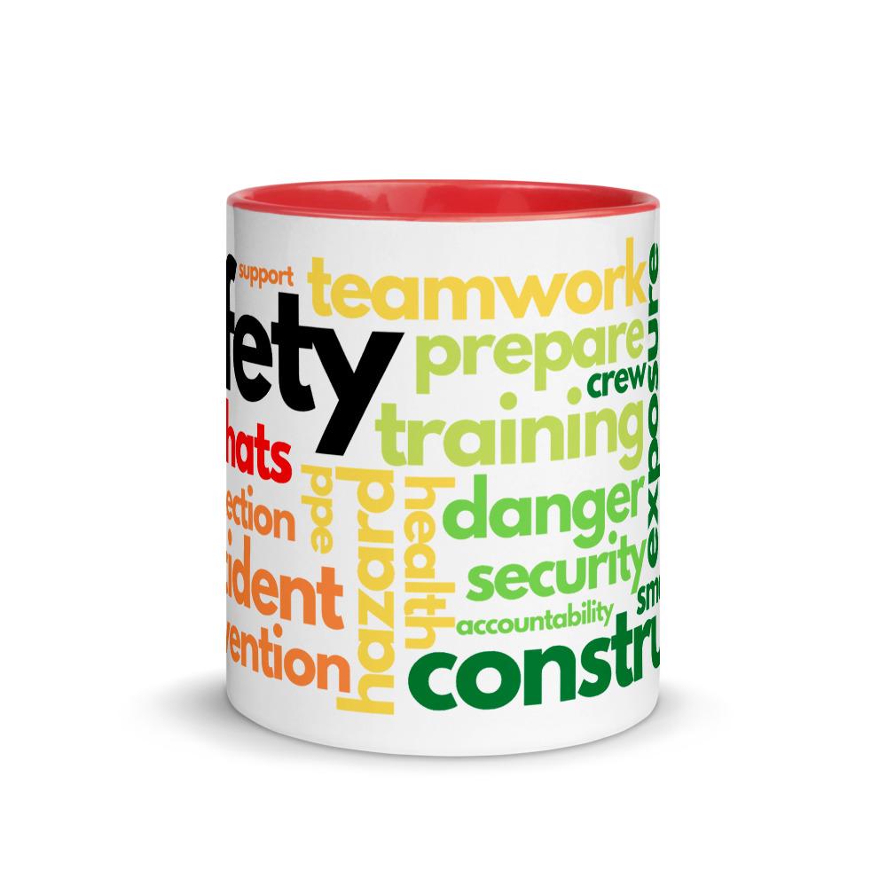 White ceramic mug with safety terms like hard hats, protection, and encourage, in a rainbow pattern across the mug with a red rim, inside, and handle.