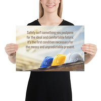 A workplace safety poster showing 3 multi colored hardhats sitting on a wall with the slogan safety isn't something you postpone for the ideal and comfortable future. It's the first condition necessary for the messy and unpredictable present.