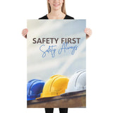A workplace safety poster showing a white, a yellow, and a blue hardhat sitting on a wall with the slogan safety first, safety always.