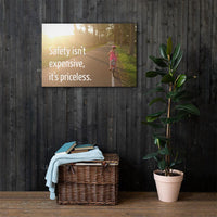 A safety poster showing a little girl riding her bike down a road on a sunny day with the slogan safety isn't expensive, it's priceless.