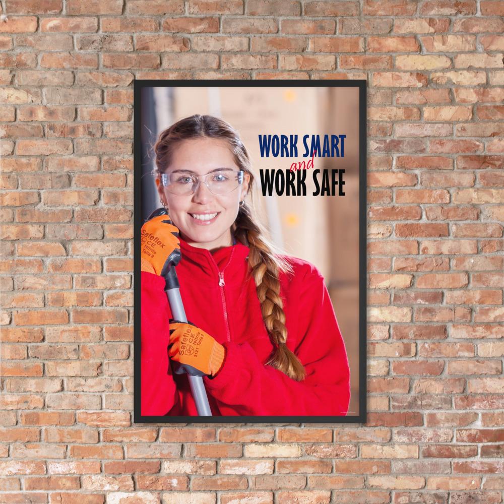 A workplace safety poster showing a warehouse worker wearing gloves and safety glasses and holding a broom and smiling with the slogan work smart and work safe.