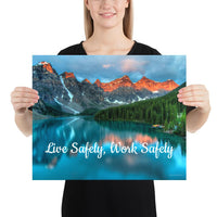 A workplace safety poster depicting a beautiful landscape of mountains with a river flowing down the side of the mountains into a bright blue pond with text saying live safely work safely.